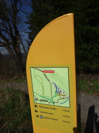 Directional signage with map at trail junctions includes mileage to destinations